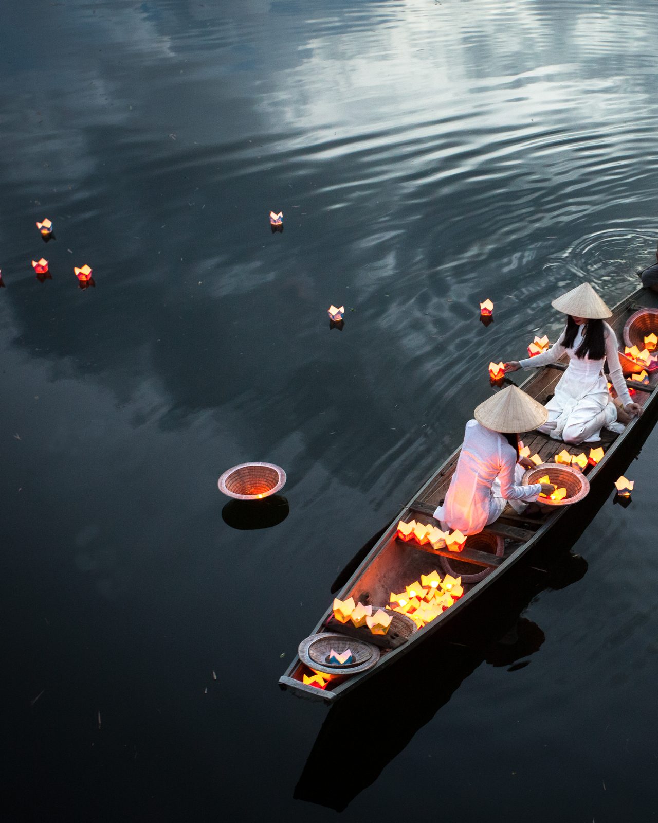 Lantern offerings on dark water, Hoi An
