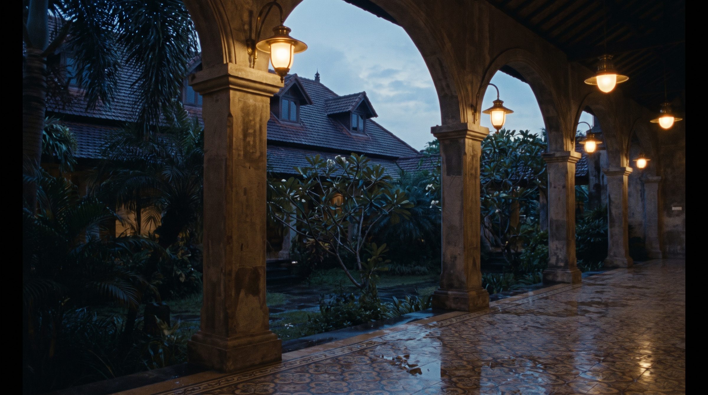 A hotel courtyard at dusk, lamps just lit
